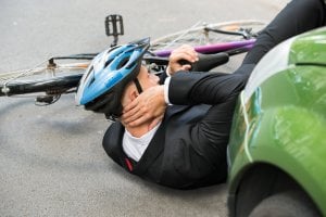 Picture of Male Cyclist With Neck Pain Lying On Street After Road Accident